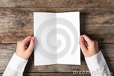 Woman holding blank brochure mock up on wooden table Stock Photo