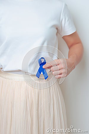 Woman holding Blue ribbon with having Abdomen pain. March Colorectal Cancer Awareness month, Colonic disease, Large Intestine, Stock Photo