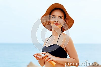 A woman holding bottles of sun cream in her hands. Skincare. Sun protection. Stock Photo