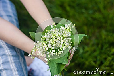 Woman holding a bouquet of lilly of valley flowers Stock Photo