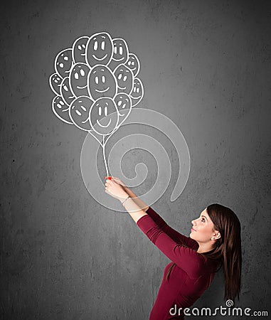 Woman holding a bunch of smiling balloons Stock Photo