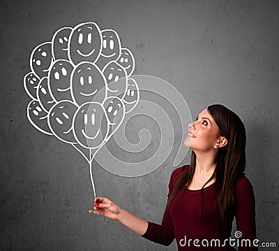 Woman holding a bunch of smiling balloons Stock Photo