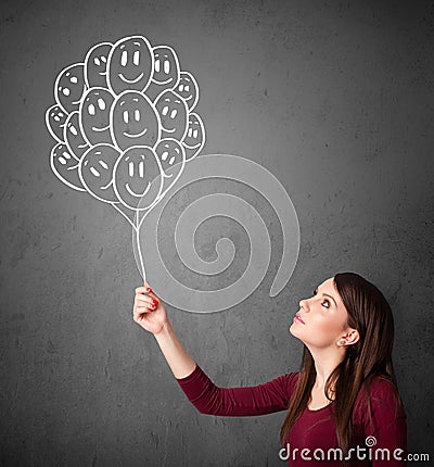 Woman holding a bunch of smiling balloons Stock Photo