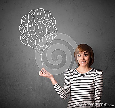 Woman holding a bunch of smiling balloons Stock Photo