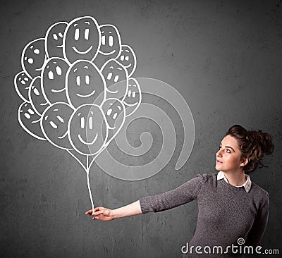 Woman holding a bunch of smiling balloons Stock Photo