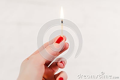 Woman holding a burning match Stock Photo