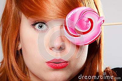 Woman holding candy. Redhair girl with sweet lollipop making fun Stock Photo