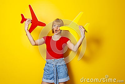 Woman holding cardboard planes thinking about next travel destinations Stock Photo