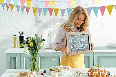 Woman holding chalkboard with happy easter Stock Photo