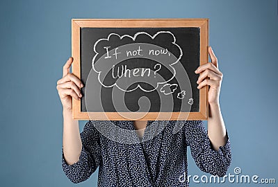 Woman holding chalkboard with phrase If not now. When? on color background. Time management concept Stock Photo