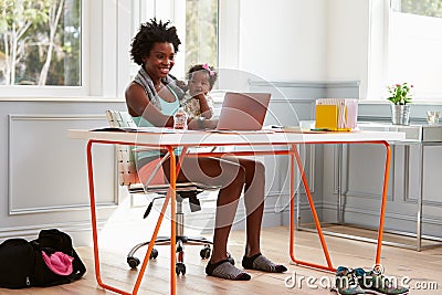Woman holding child using computer at home after exercising Stock Photo
