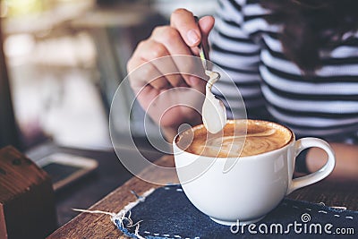 A woman holding coffee spoon to stir hot coffee Stock Photo