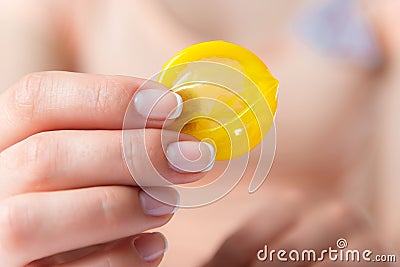 Woman holding condom in hand Stock Photo