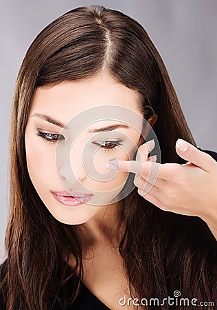 Woman holding contact lens on finger Stock Photo