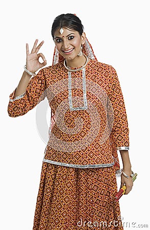 Woman holding a Dandiya at Navratri and making ok sign Stock Photo