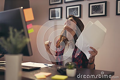 Woman holding documents joyful after a business success Stock Photo