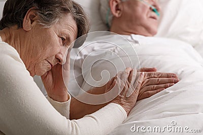 Woman holding dying husband`s hand Stock Photo