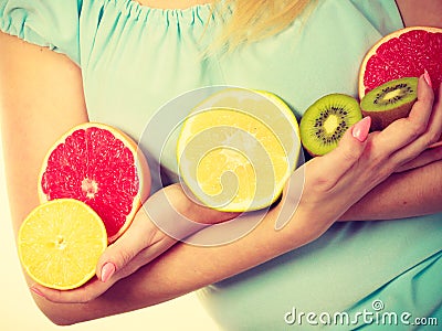 Woman holding fruits kiwi. orange, lemon and grapefruit Stock Photo