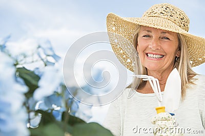 Woman Holding Gardening Fork And Trowel Against Sky Stock Photo