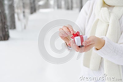 Woman holding a gift and begins to open it. Stock Photo