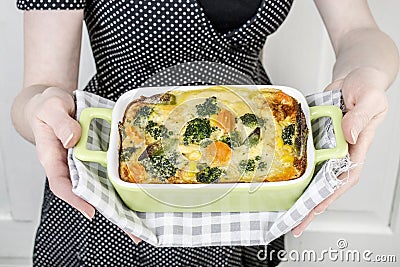 Woman holding a gratin in green bowl Stock Photo