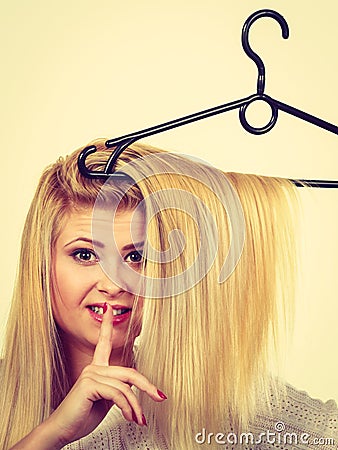 Woman holding hair on clothes hanger Stock Photo