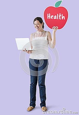 Woman holding a health icon and using a laptop Stock Photo