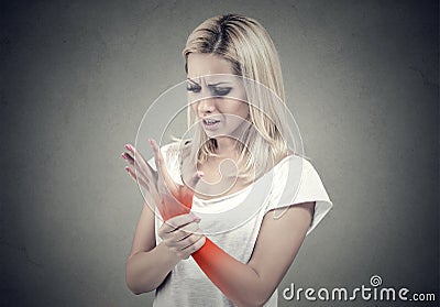 Woman holding her painful wrist. Sprain pain location indicated by red spot. Stock Photo