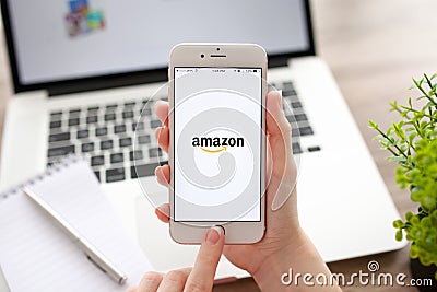 Woman holding iPhone 6S Rose Gold with Amazon on screen Editorial Stock Photo