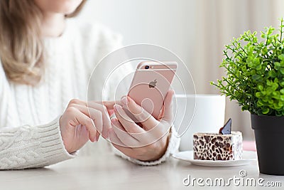 Woman holding iPhone 6 S Rose Gold in cafe Editorial Stock Photo