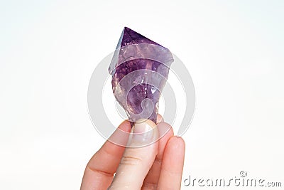 Woman holding Large Amethyst Phantom Point from Brazil in her hand at sunrise in front of the lake Stock Photo