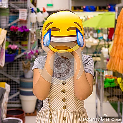Woman holding a laugh emoji pillow Stock Photo
