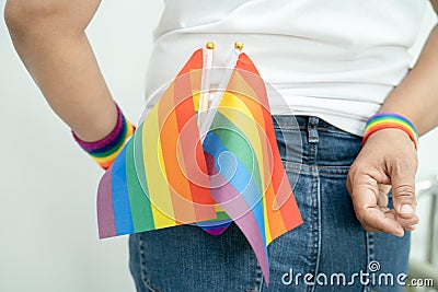 Woman holding LGBT rainbow colorful flag, symbol of lesbian, gay, bisexual, transgender, human rights, tolerance and peace Stock Photo