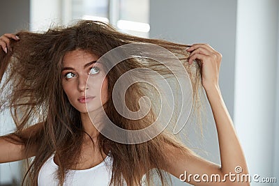 Woman With Holding Long Damaged Dry Hair. Hair Damage, Haircare. Stock Photo