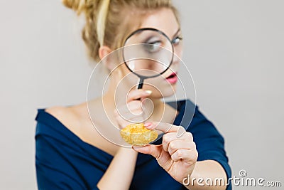 Woman holding magnifying glass investigating bread Stock Photo