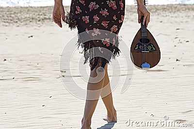 Woman holding a mandolin at the beach Stock Photo