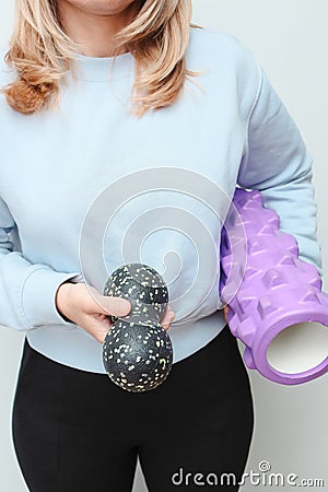 Woman holding massage rollers for myofascial release in her hands. Fitness trainer with items for myofascial release Stock Photo