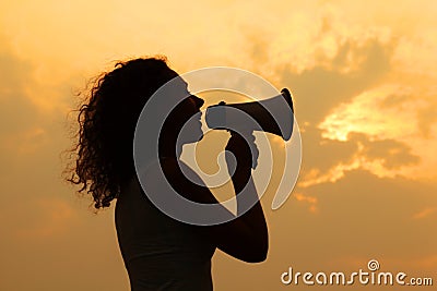 Woman holding megaphone at sunset Stock Photo