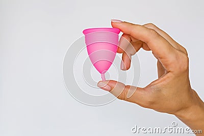 woman holding menstrual cup on white background. Feminine hygiene alternative product instead of tampon during period. Stock Photo