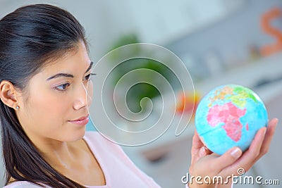 Woman holding miniature globe Stock Photo