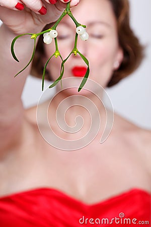 Woman holding mistletoe kissing Stock Photo