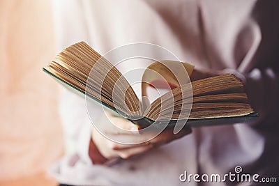 Woman holding open book, turning pages, reading Stock Photo