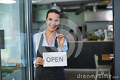 Woman holding open sign in cafe Stock Photo