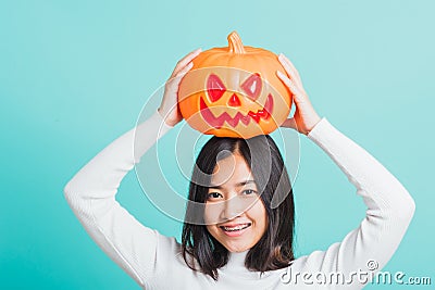 Woman holding orange model pumpkins and put it on the head Stock Photo