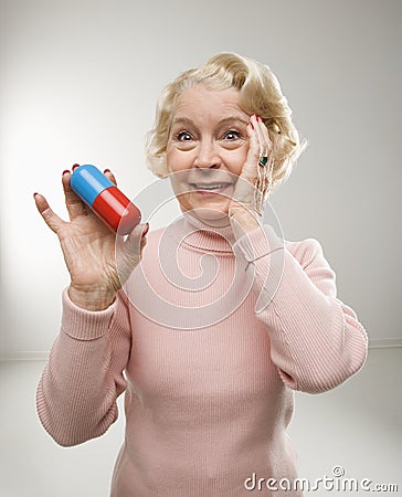 Woman holding oversized pill. Stock Photo