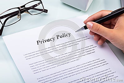 Woman Holding Pen Over Privacy Policy Form Stock Photo