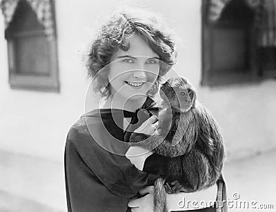 Woman holding a pet monkey in her arms Editorial Stock Photo