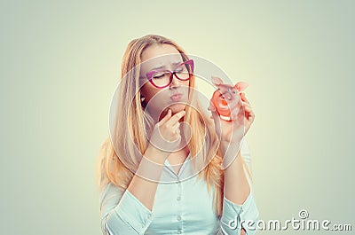 Woman holding piggy thinking cute Stock Photo