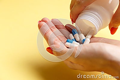 Woman holding pills on hand Stock Photo