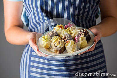 Woman Holding Plate Of Delicious Homemade Cupcakes Stock Photo